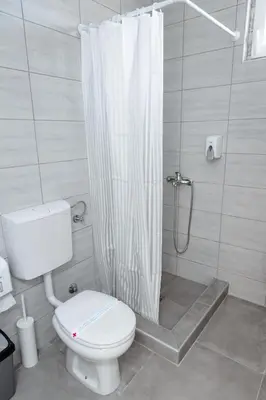 a bathroom with a toilet and a shower curtain at Đerdan Garden apartments in Kraljevo
