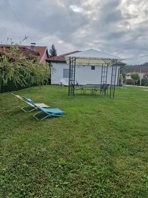 a gazebo with a picnic table and chairs in a yard at Đerdan Garden apartments in Kraljevo