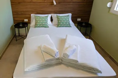 a white bed with towels on top of it at Đerdan Garden apartments in Kraljevo