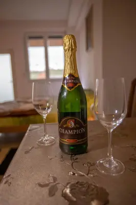 a bottle of champagne with two wine glasses on a table at Apartmani Lazić in Ribarska Banja