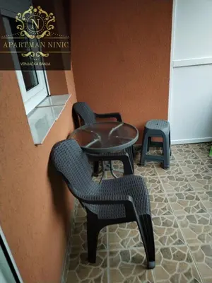 a room with two chairs and a table and a stool at Apartman Ninic in Vrnjačka Banja
