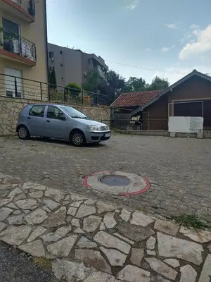 a car parked in a parking lot next to a building at Apartman Ninic in Vrnjačka Banja
