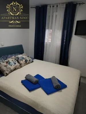 a bed with two blue towels on top of it at Apartman Ninic in Vrnjačka Banja