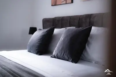 a bed with two black pillows on it at J&S Apartments in Niš