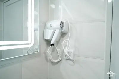 a white phone hanging on a wall in a bathroom at J&S Apartments in Niš