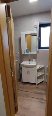 a bathroom with a sink and a mirror at Jela Apartman in Soko Banja