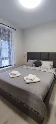 a bedroom with a large bed with two towels on it at Jela Apartman in Soko Banja