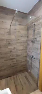 a bathroom with a shower with a glass door at Jela Apartman in Soko Banja