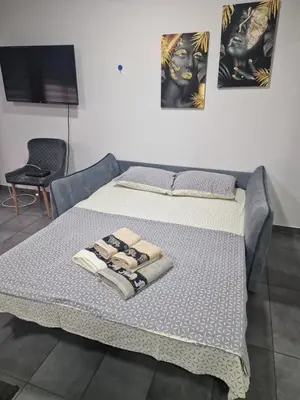 a bed in a room with two towels on it at Silver city studio in Jagodina