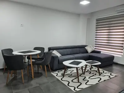a living room with a couch and two tables and chairs at Silver city studio in Jagodina