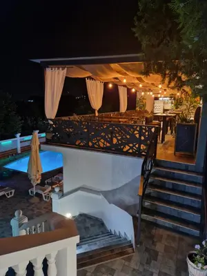 a set of stairs leading to a patio at night at Garni Hotel Panorama Lux in Niš