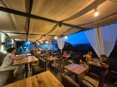 a group of people sitting at tables in a restaurant at Garni Hotel Panorama Lux in Niš