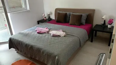 a bedroom with a large bed with pink clothes on it at Apartman Rubi Sokobanja in Soko Banja