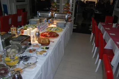 a long table with plates of food and candles at Garni Hotel Crystal in Kraljevo