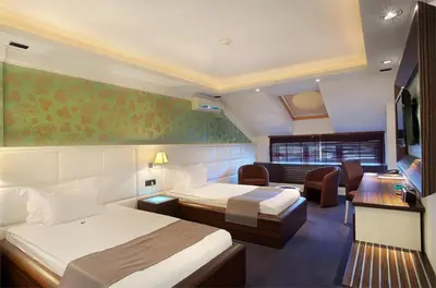 a hotel room with two beds and a couch at Garni Hotel Crystal in Kraljevo
