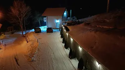 a snow covered street at night with a building at Vila Vlasina in Vlasina Rid