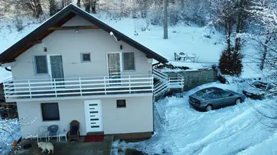 a house with a car parked in the snow at Vila Vlasina in Vlasina Rid