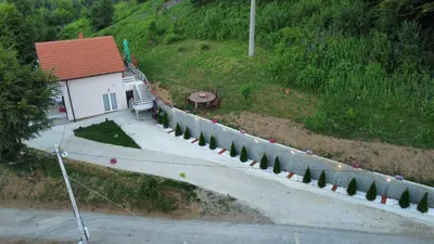 a house on a hill with a road and trees at Vila Vlasina in Vlasina Rid