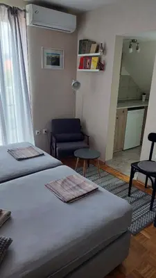 a room with two beds and a living room at Apartmani Filip in Vrnjci