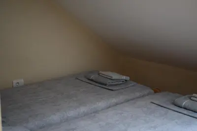 two beds in a attic room with towels on them at Apartmani Filip in Vrnjci