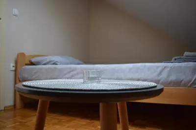 a glass on a table in a room with a bed at Apartmani Filip in Vrnjci