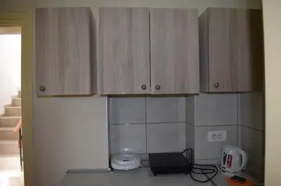 a kitchen with wooden cabinets on the wall at Apartmani Filip in Vrnjci