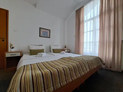 a large bed in a room with a large window at Hotel Marica in Niš