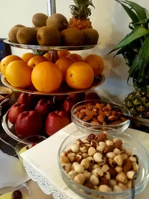 a table with three tiers of fruits and nuts at Hotel Marica in Niš