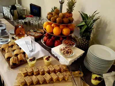 a table topped with a display of food and fruit at Hotel Marica in Niš