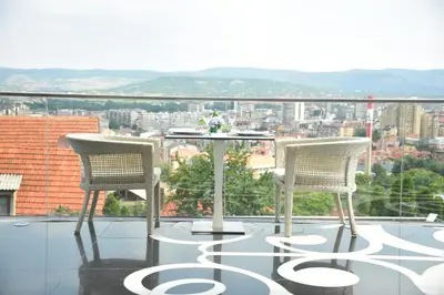 two chairs and a table on a balcony with a view at Hotel Marica in Niš