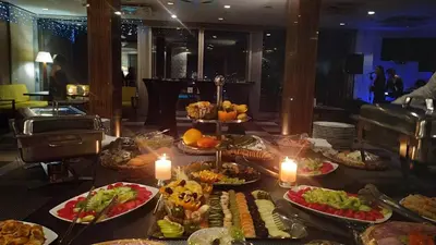 a buffet of food on a table with candles at Hotel Marica in Niš