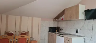 a kitchen with wooden cabinets and a table and chairs at Vila Dubrovnik in Vrnjačka Banja