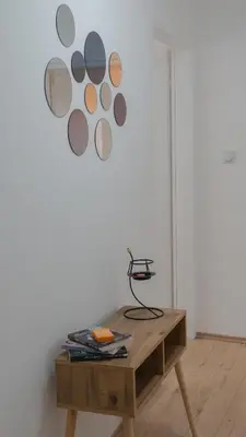 a wooden table in front of a wall with a painting at Apartmani Bubamara Leskovac in Leskovac