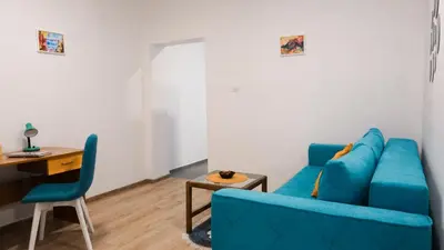 a living room with a blue couch and a table at Apartmani Bubamara Leskovac in Leskovac