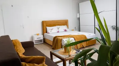 a bedroom with a bed and a couch and a table at Apartmani Bubamara Leskovac in Leskovac