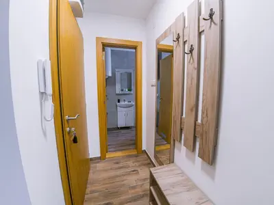 a hallway with a bathroom with a sink and a mirror at Apartman Bellini 2 in Soko Banja