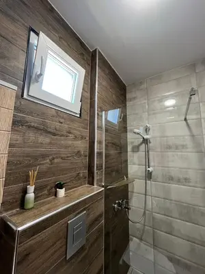 a bathroom with a shower with a window and a sink at Apartmani Bosfor in Niška Banja