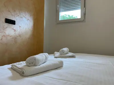 two towels are sitting on top of a bed at Apartmani Bosfor in Niška Banja