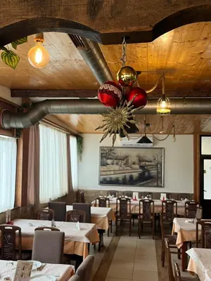 a dining room with tables and chairs and a chandelier at Apartmani Bosfor in Niška Banja