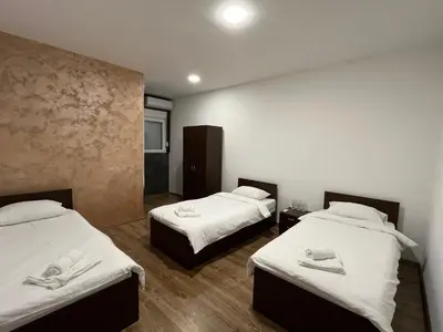 two beds in a room with white sheets at Apartmani Bosfor in Niška Banja