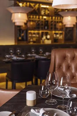 a table with wine glasses on a table in a restaurant at Hotel Grand Kopaonik in Kopaonik