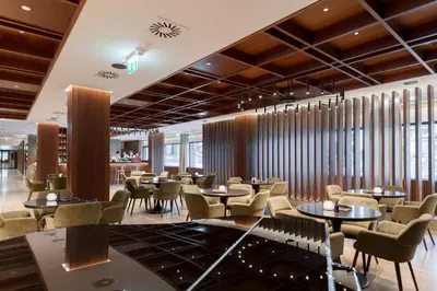 a restaurant with tables and chairs and windows at Hotel Grand Kopaonik in Kopaonik