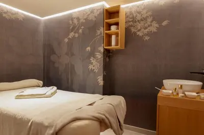 a bathroom with a bed and a sink in a room at Hotel Grand Kopaonik in Kopaonik