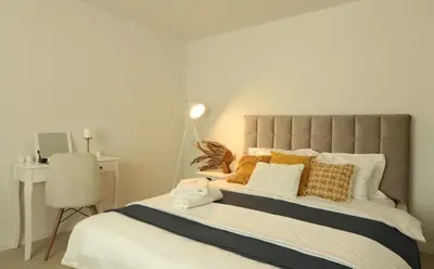 a bedroom with a large bed with pillows and a desk at Kuća sa bazenom do 10 osoba Freedom Place in Jagodina