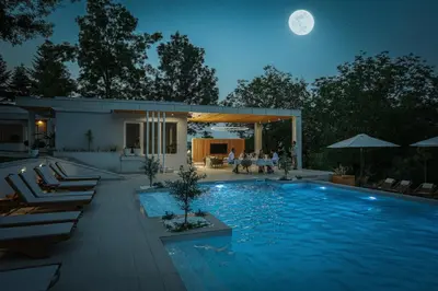 a large swimming pool at night with a full moon at Kuća sa bazenom do 10 osoba Freedom Place in Jagodina