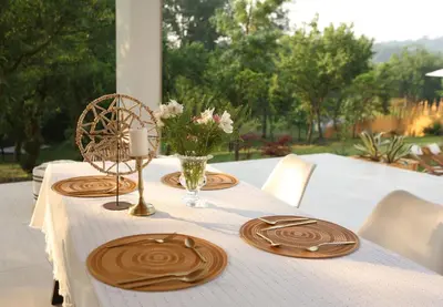 a table with a white table cloth and wooden plates on it at Kuća sa bazenom do 10 osoba Freedom Place in Jagodina