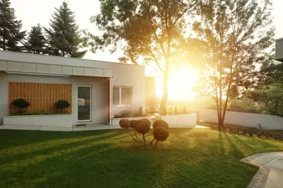 a house with the sun shining in the yard at Kuća sa bazenom do 10 osoba Freedom Place in Jagodina