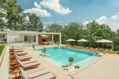 an image of a swimming pool with lounge chairs and umbrellas at Apartmani Freedom place in Jagodina