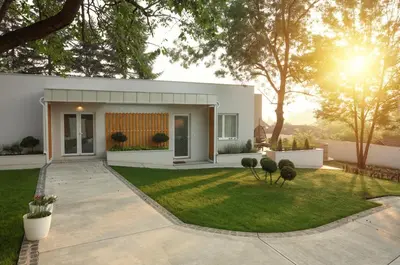 a white house with a green yard at Apartmani Freedom place in Jagodina