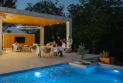 a group of people standing on a patio next to a pool at Apartmani Freedom place in Jagodina